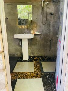 a bathroom with a sink and a shower at Belihuloya Fattah Camping Resort in Belihul Oya
