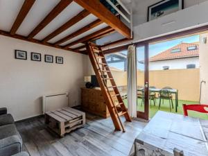 ein Wohnzimmer mit einer Leiter und ein Zimmer mit einem Tisch in der Unterkunft Charmant appartement avec mezzanine et parking - 4 pers - FR-1-521-263 in Biscarrosse-Plage