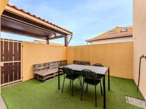 eine Terrasse mit einem Tisch, Stühlen und einer Bank in der Unterkunft Charmant appartement avec mezzanine et parking - 4 pers - FR-1-521-263 in Biscarrosse-Plage
