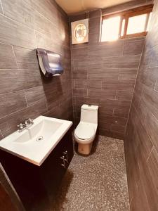 a bathroom with a toilet and a sink at Lartbook Mty in Monterrey