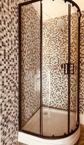 a shower in a bathroom with black and white tiles at Lartbook Mty in Monterrey
