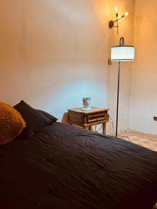 a bedroom with a bed and a lamp and a table at Lartbook Mty in Monterrey +3 photos