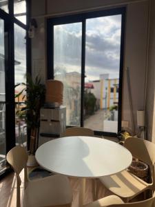 een witte tafel en stoelen in een kamer met een raam bij Loftvibes San Juan - Unit 5 in San Juan