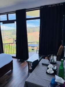 a room with a table and a large window at Nidha Home in Ooty