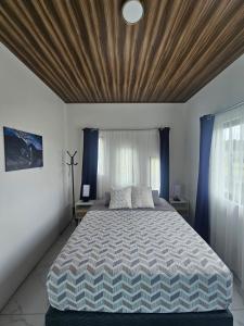 a bedroom with a large bed with a wooden ceiling at Casa Tigrillo - La Fortuna in Agua Azul