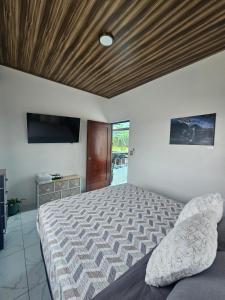 a bedroom with a bed with a wooden ceiling at Casa Tigrillo - La Fortuna in Agua Azul