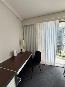 Cette chambre dispose d'une fenêtre et d'un bureau avec une chaise. dans l'établissement Ocean-view hotel room on Level 17 in central Surfers Paradise, à Gold Coast