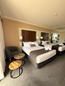 une chambre d'hôtel avec deux lits et une chaise dans l'établissement Ocean-view hotel room on Level 17 in central Surfers Paradise, à Gold Coast