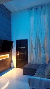 a bedroom with a bed and a blue curtain at Cataratas Paradise - O seu conforto na natureza! in Foz do Iguaçu