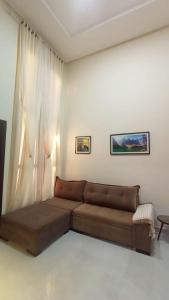 a living room with a brown couch in a room at Cataratas Paradise - O seu conforto na natureza! in Foz do Iguaçu