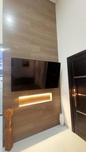 a television on a wall with a wooden wall at Cataratas Paradise - O seu conforto na natureza! in Foz do Iguaçu