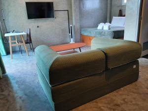 ein Wohnzimmer mit einem Sofa in einem Hotelzimmer in der Unterkunft Momems House in Ban Tha Pai