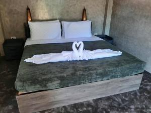 ein Schlafzimmer mit einem Bett mit zwei weißen Schwänen darauf in der Unterkunft Momems House in Ban Tha Pai