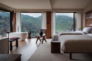 a bedroom with two beds and a tub and a view at See the mountains, find the place to stay in Xijiang