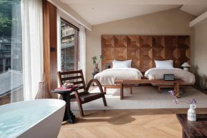 a bedroom with two beds and a bath tub at See the mountains, find the place to stay in Xijiang