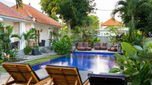 a pool in a yard with chairs and a house at Adi Abian Uluwatu by Tanya Pink in Uluwatu +16 photos
