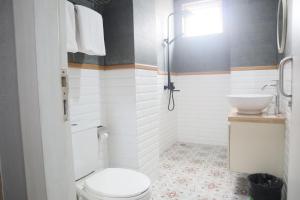 a bathroom with a toilet and a sink at Twin Tower Hotel & Residence in Surabaya +21 photos