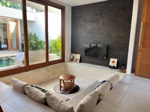 a living room with a couch and a tv at Casa Gemellia Brand New 2BR in Umalas in Kerobokan