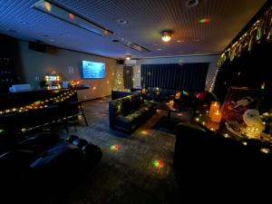 un soggiorno con divani e un bar con luci di 貸切宿さうなす a Nasushiobara