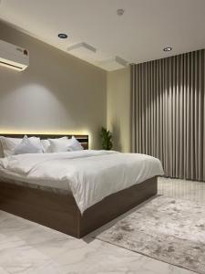 een slaapkamer met een groot bed en een groot raam bij نزل Rest in Hail