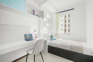 a bedroom with a bed and a desk and a window at Javen by Kozystay - Thamrin in Jakarta +25 photos