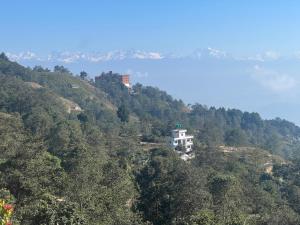 a house on top of a hill with a body of water at Hotel Pigeon Prince in Nagarkot