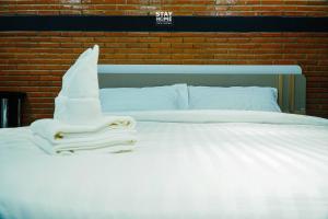 a white bed with towels on top of it at Loft Hatyai l ลอฟท์หาดใหญ่ in Hat Yai +34 photos