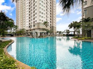a large swimming pool in front of two tall buildings at Javen by Kozystay - Thamrin in Jakarta