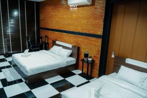a bedroom with two beds and a checkered floor at Loft Hatyai l ลอฟท์หาดใหญ่ in Hat Yai