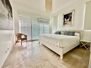 une chambre avec un lit, une chaise et une fenêtre dans l'établissement Playa Bonita Modern Beachfront Penthouse Retreat, à La Ceiba 40 autres photos
