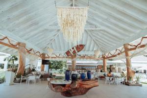 Cette grande chambre comprend un lustre, des tables et des chaises. dans l'établissement Playa Bonita Modern Beachfront Penthouse Retreat, à La Ceiba