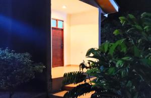 a house with a red door and some plants at Madonna 1BR Apartment with Fast WiFi and Pool in Morogoro