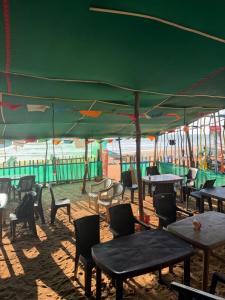 ゴカルナにあるGokarna Beach Near Stayの緑のテントの下のテーブルと椅子
