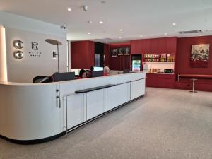 Un vestíbulo con un mostrador blanco y armarios rojos. en Miico Hotel Permas Jaya, en Johor Bahru
