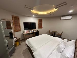 a bedroom with a bed and a flat screen tv at 계룡 호텔 스테이318 in Gyeryong