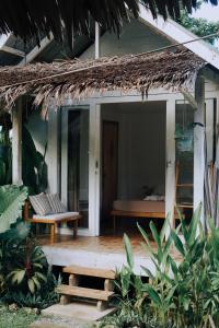 un porche de maison avec un banc et un lit dans l'établissement Verde Bungalows Siargao, à General Luna