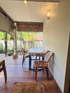 a table and chairs sitting on a patio at Marari diya homestay in Mararikulam