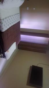 Una habitación con un banco con una luz violeta. en Morgan Suites, en Kampala 1 foto más