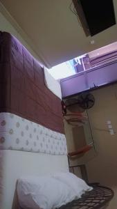 Un dormitorio con una cama con cabecero de madera. en Morgan Suites, en Kampala