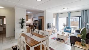 una cucina e un soggiorno con un tavolo e un divano di The Blyde @ 485 a Pretoria