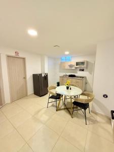 a room with a table and chairs and a kitchen at The Host apartamentos At Los Angeles in Santa Marta
