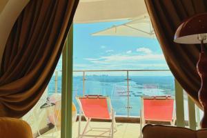 un balcon avec deux chaises et une vue sur l'eau dans l'établissement Country Garden Fully Unblocked Seaview Suite by Dooga's Homestay, à Johor Bahru