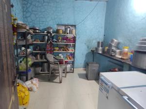 a kitchen with blue walls and a table with a chair at Dongre's Farm, Malshej Ghat in Junnar