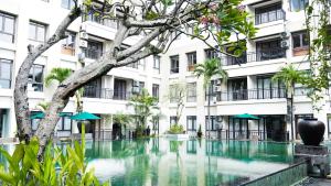 a swimming pool in front of a building at Grand Kuta Hotel and Residence in Legian