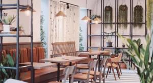 a restaurant with tables and chairs and plants at Fun Hotel in Ban Thai Wat Khot