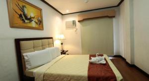 CabaguioにあるD' Leonor Hotelのベッドルーム1室(靴1足付きのベッド1台付)