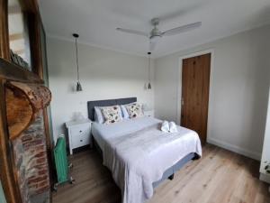 ein weißes Schlafzimmer mit einem Bett und Holzboden in der Unterkunft Grasmere Farm in Gruyere