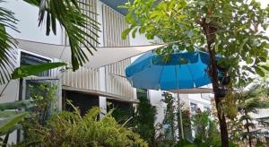 ein blauer Regenschirm vor einem Gebäude in der Unterkunft Daddy's home Huahin in Hua Hin