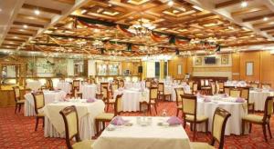 KenliにあるDongying Dongsheng Hotelの白いテーブルと椅子のあるダイニングルーム