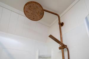 a shower head in a bathroom with white tiles at Okawa Bay Lakeside - Lake Rotoiti A-Frame in Mourea